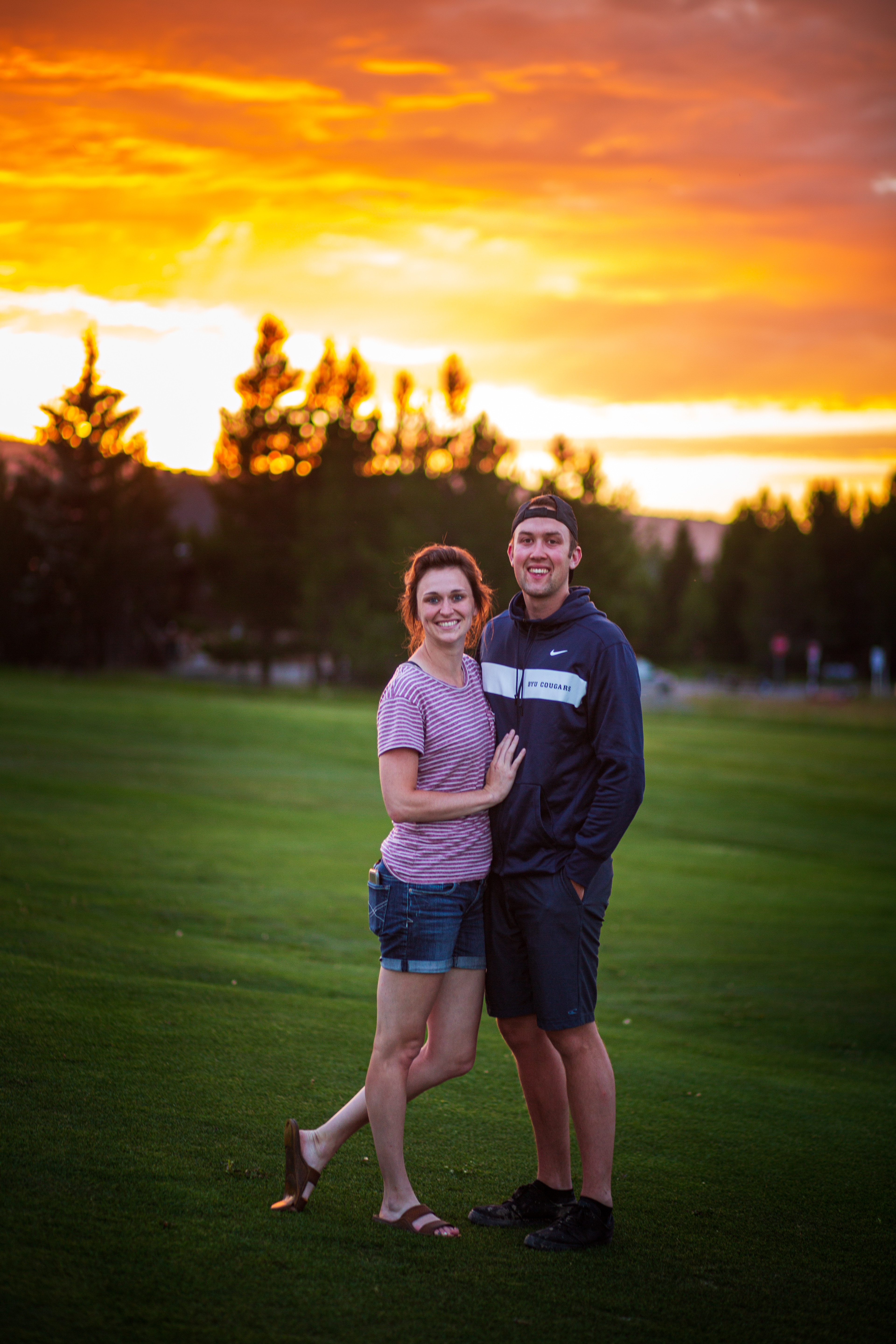 Couple standing together and smiling at the camera at sunset